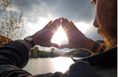 hands in triangle with sun