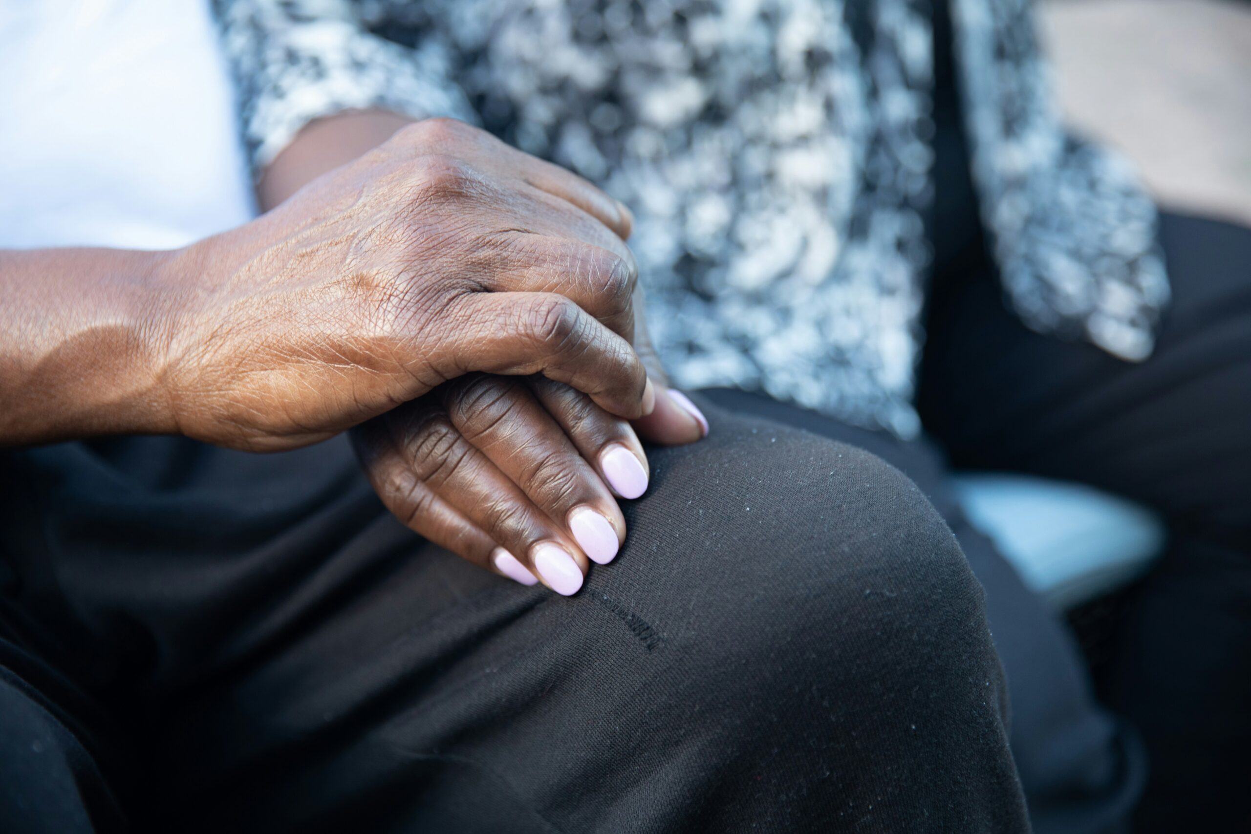 Close up image of older couple holding hands together on lap