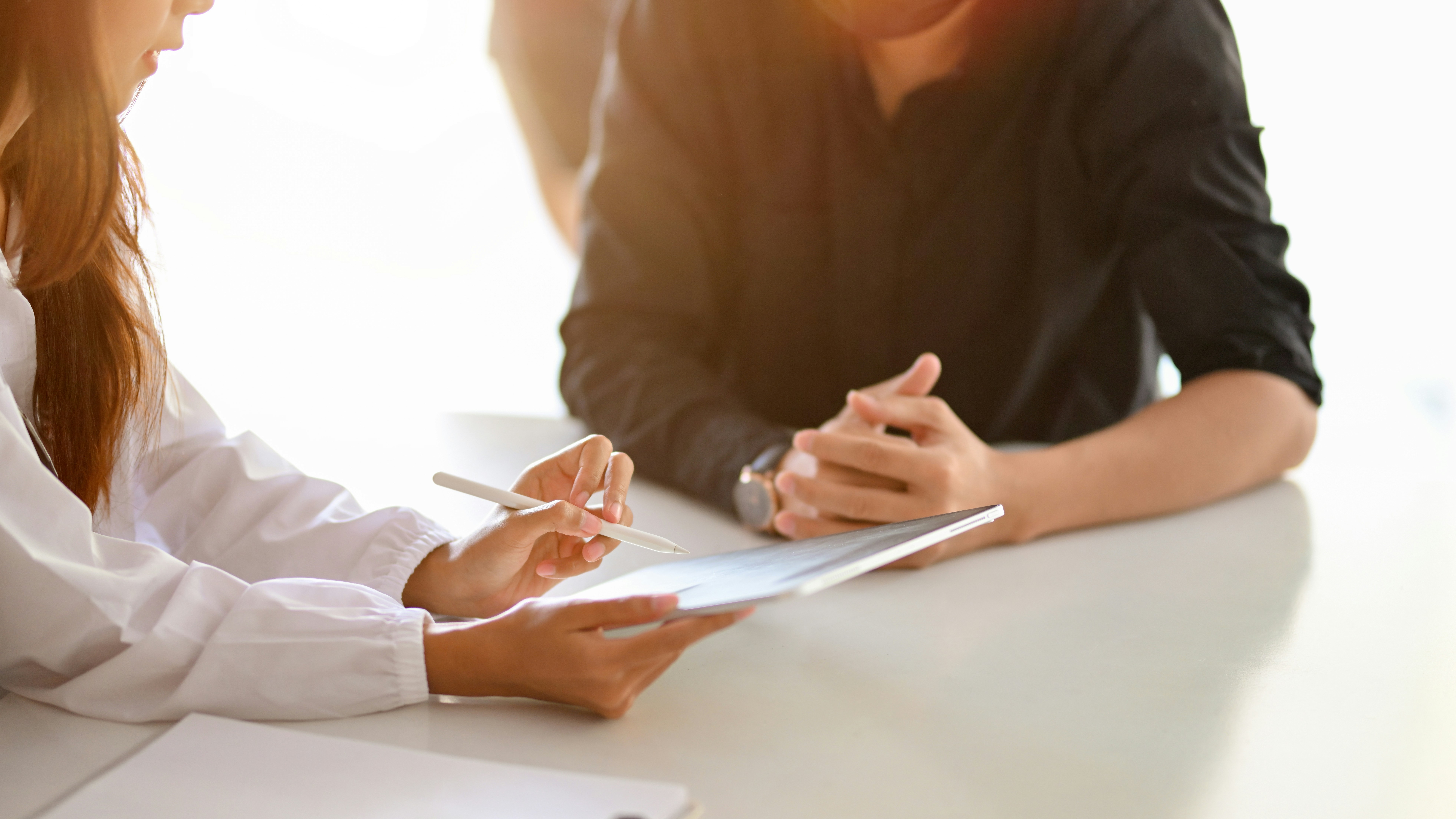 Close up of doctor meeting with a patient, while pointing to a clipboard.