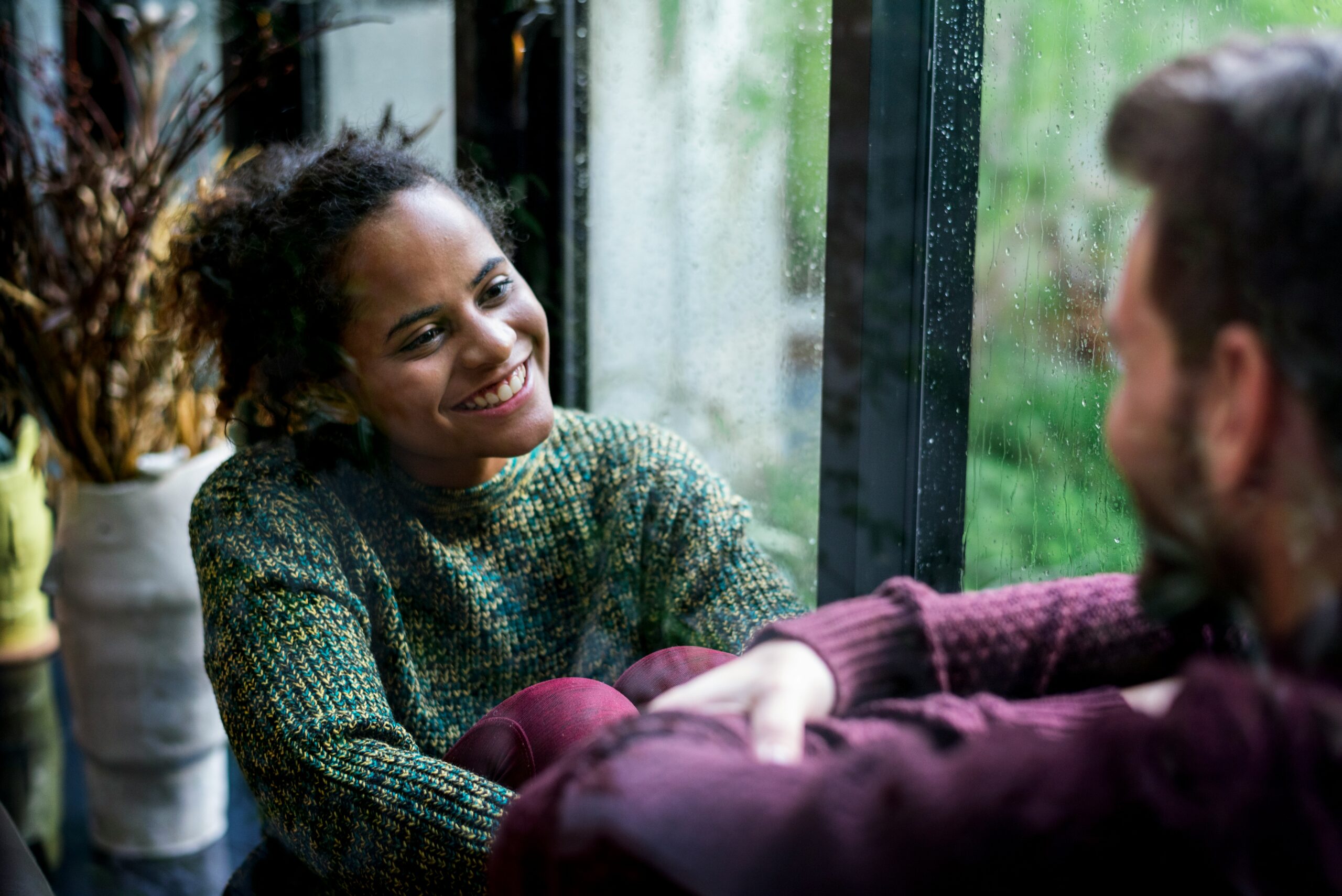 Woman smiling during conversation with a man sitting across from her
