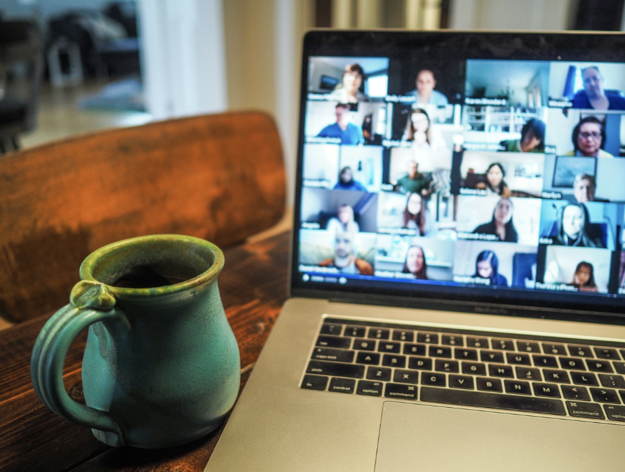 Laptop with Zoom video conference on the screen with multiple people on the call.