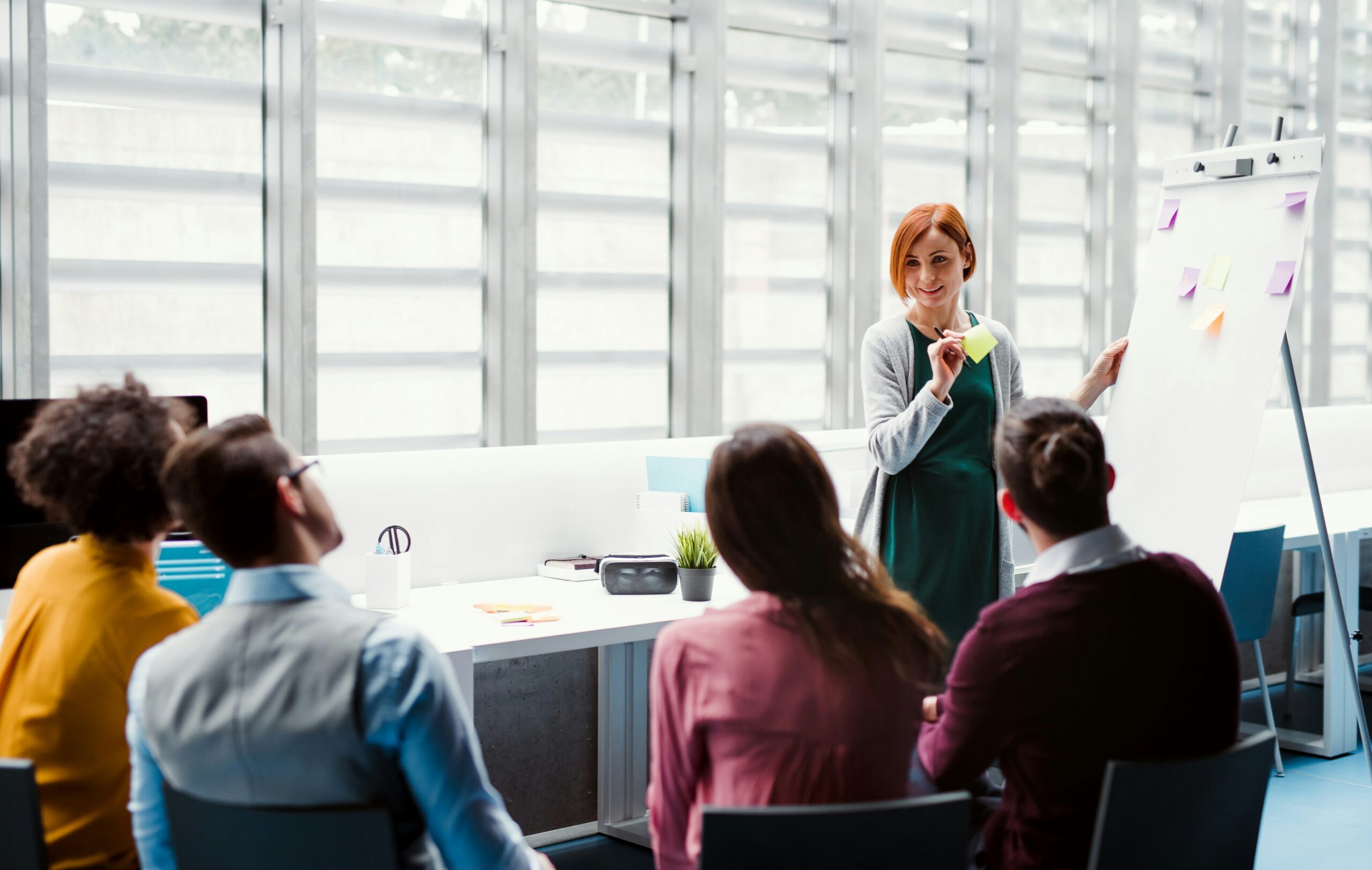 Woman standing by a flip chart in front of a focus group