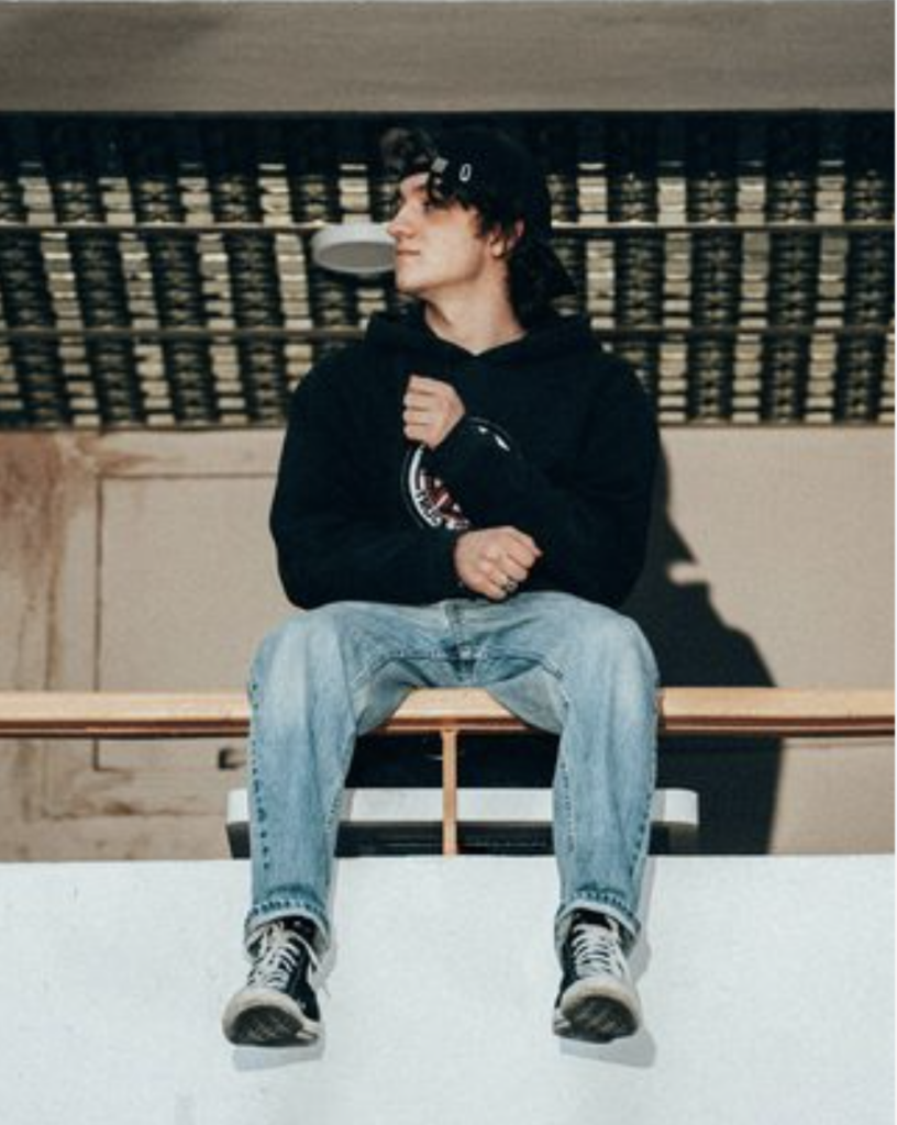 Teenage boy sitting on a ledge "air drumming"